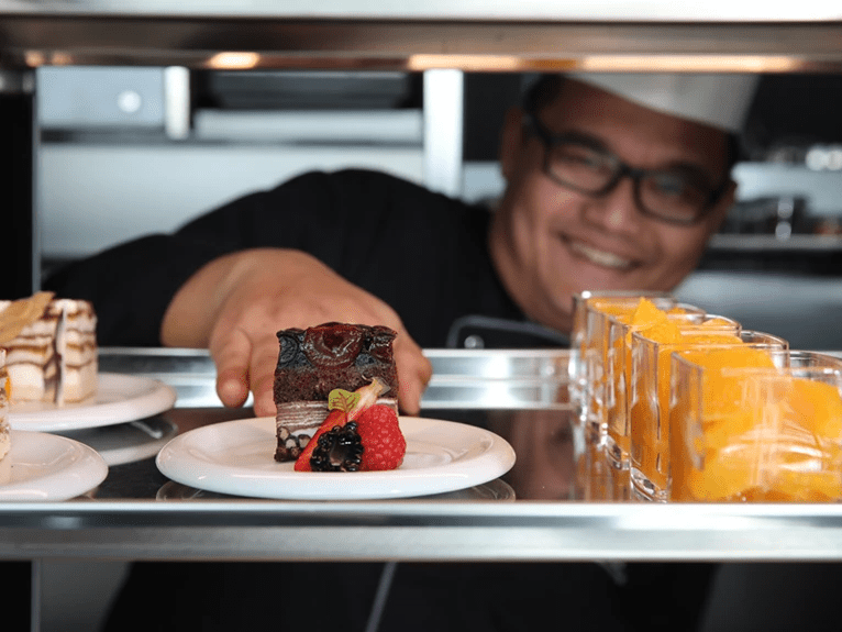 A Chef presenting a dessert at the River Café on a Scenic cruise ship.