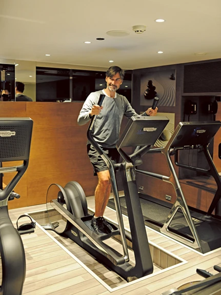 A man working out on equipment in the gym on the Scenic Jasper cruise ship.