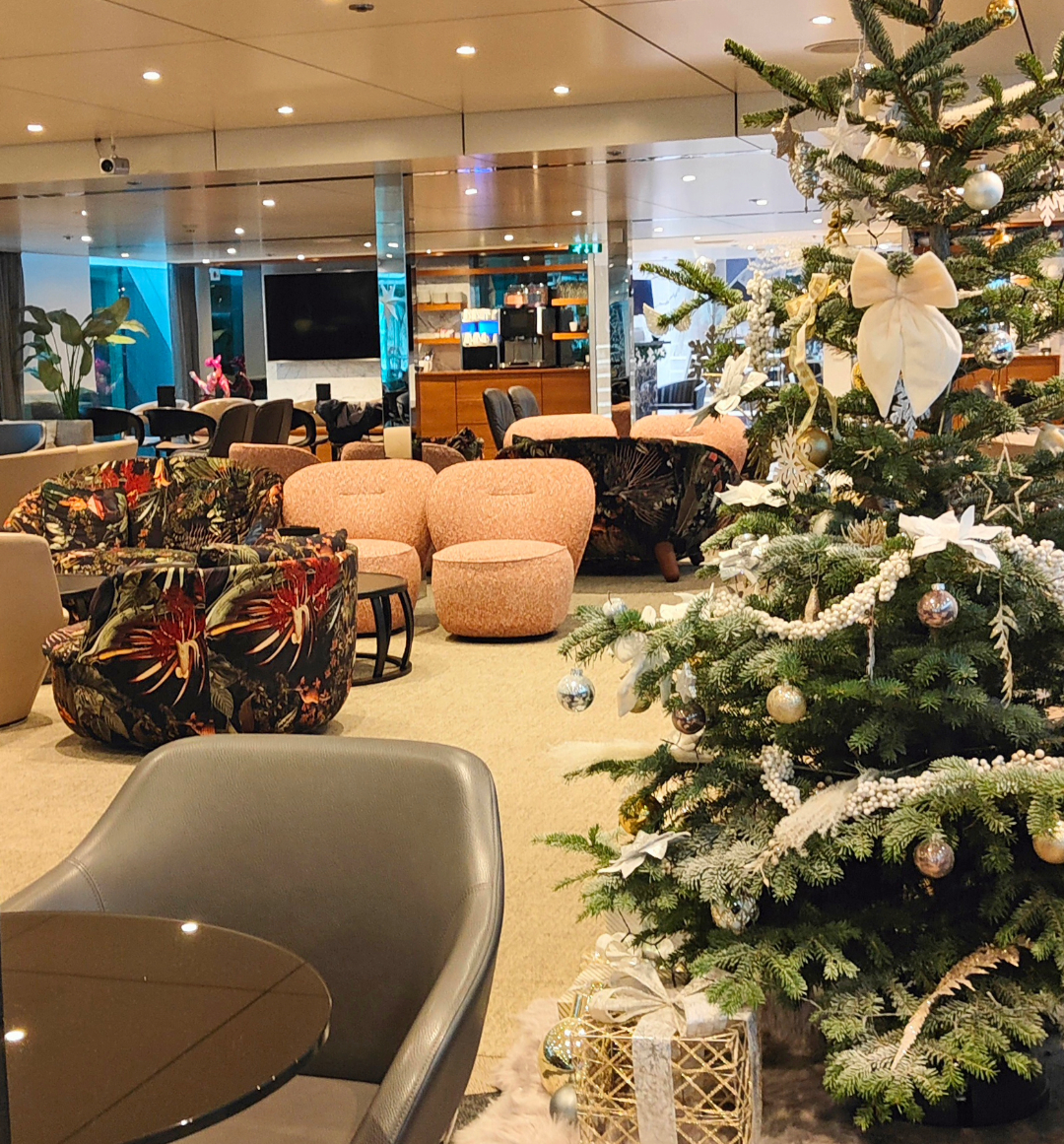 Scenic ship decorated festively with Christmas tree in lounge