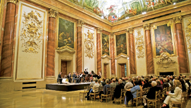 The expansive Palais Liechenstein room highlighted by a stunning ceiling painting, displaying artistic craftsmanship and captivating imagery.