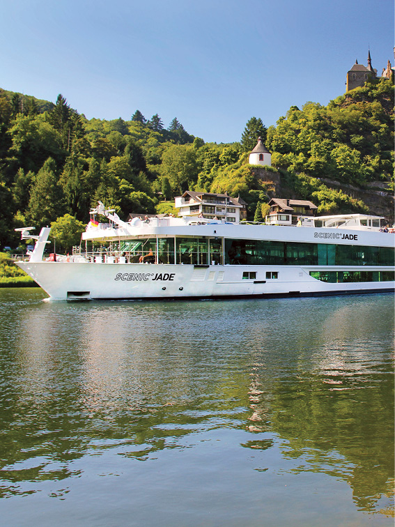 luxury river cruise ship sailing down a river in front of the Reichsburg Castle
