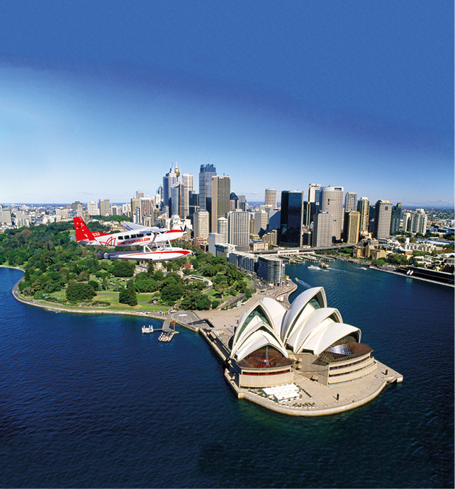Aerial shot of Sydney Harbour, with a Seaplane flying over the Sydney Opera House