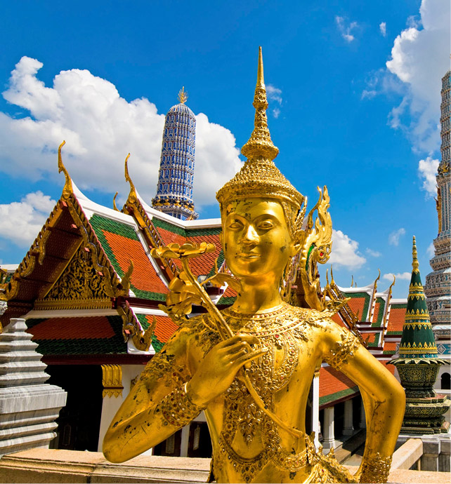 Gold statue with the Grand Palace of Bangkok in the backgorund