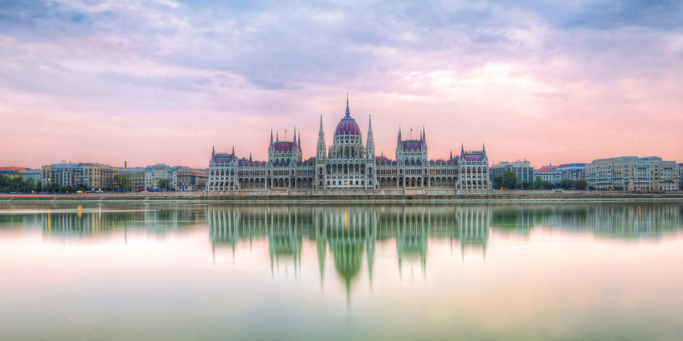 Reflection of the Hungarian Parliament Building shimmering in the water, showcasing its architectural beauty and grandeur.