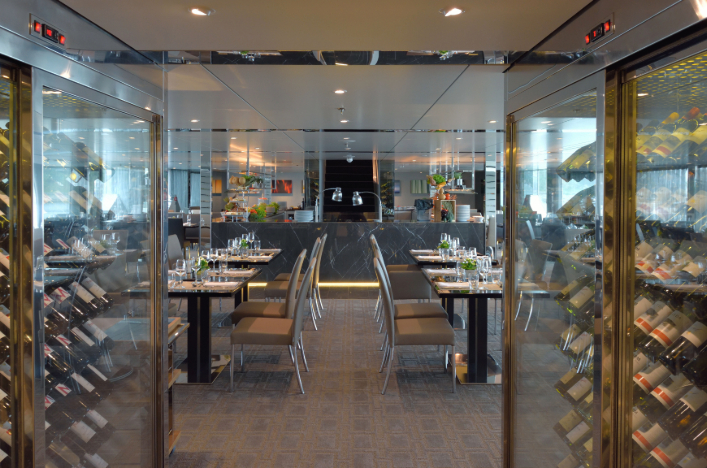 The sophisticated restaurant on Scenic Azure featuring an elegant wine cellar filled with various bottles of fine wine.